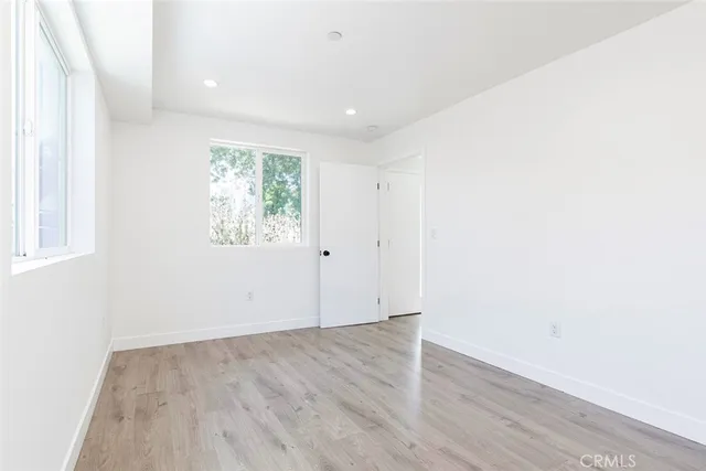 an empty room with wooden floor and window