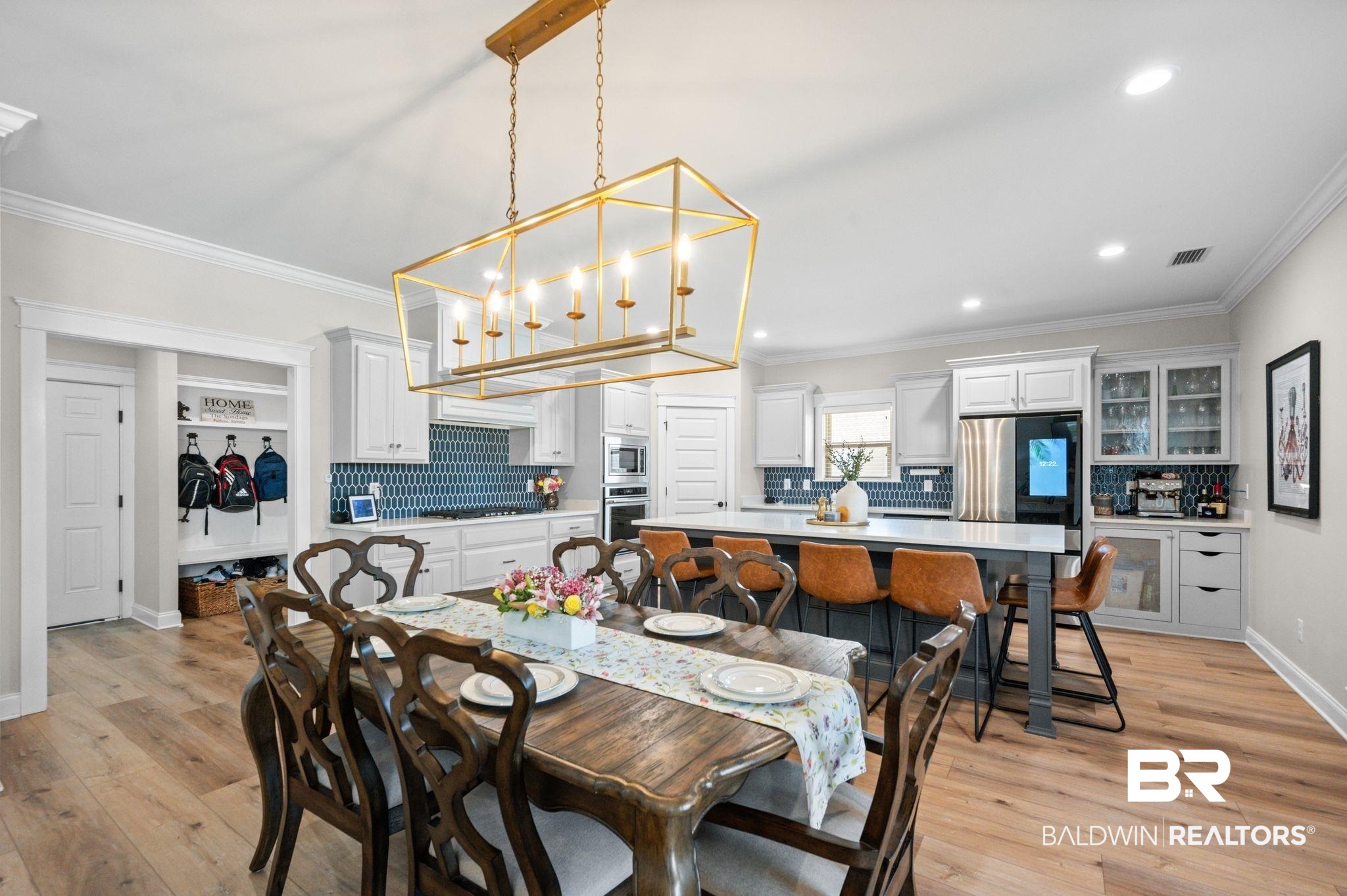 409 Fortune Drive Fairhope, AL 36532 - Photo 9 of 42 Open-concept living area featuring wood-finish flooring, a contemporary geometric chandelier, and white crown molding