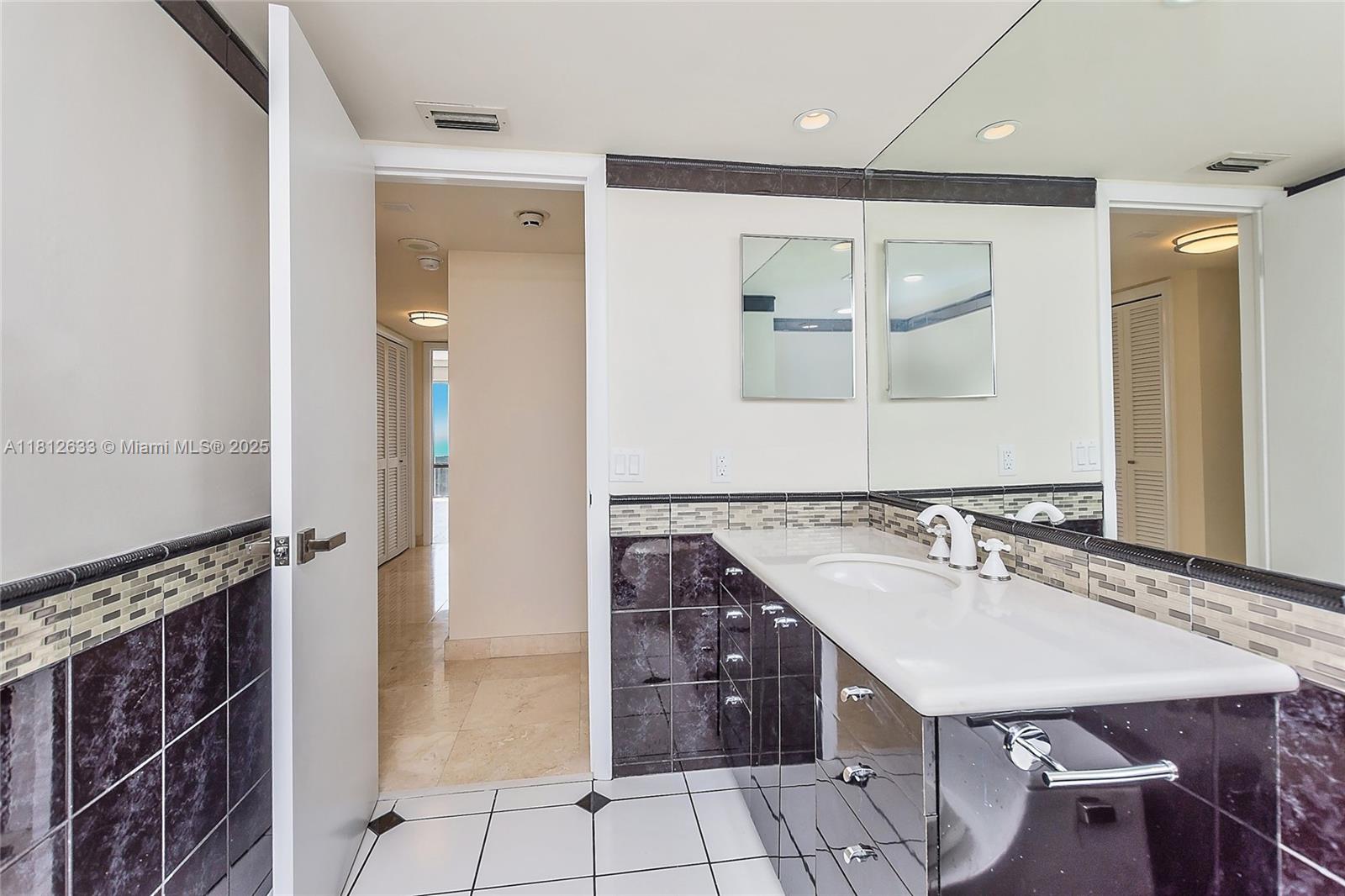 881 Ocean Drive, Unit 22A Key Biscayne, FL 33149 - Photo 21 of 26 a bathroom with a sink a vanity and a mirror