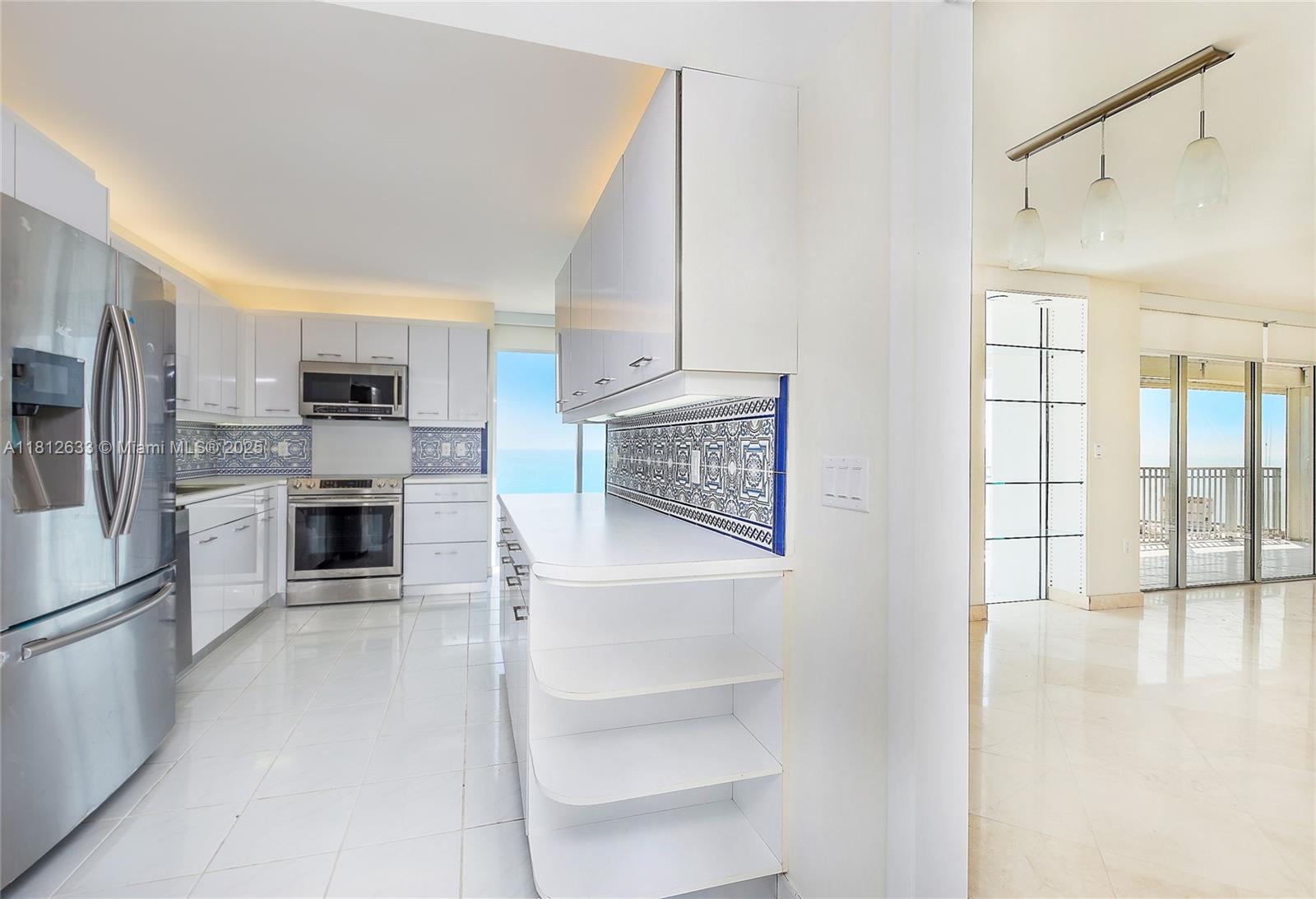 881 Ocean Drive, Unit 22A Key Biscayne, FL 33149 - Photo 5 of 26 a kitchen with granite countertop a refrigerator and a stove top oven