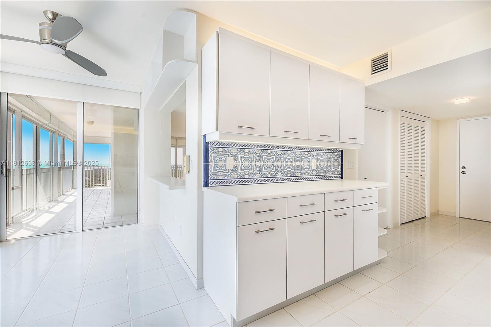 881 Ocean Drive, Unit 22A Key Biscayne, FL 33149 - Photo 6 of 26 a kitchen with white cabinets