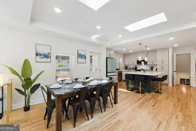a kitchen with stainless steel appliances kitchen island granite countertop a table chairs sink and cabinets