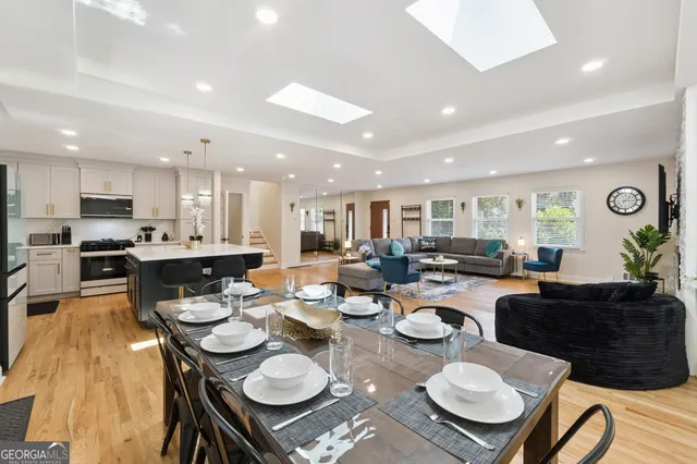 a large kitchen with lots of counter space a sink appliances and a dining table