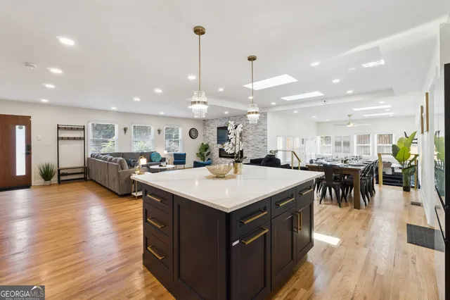 a living room with furniture large window and wooden floor