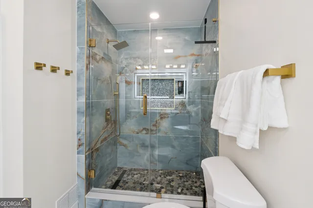 a en suite bathroom with a granite countertop sink and a mirror