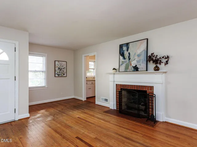 a view of a livingroom with wooden floor and a fireplace