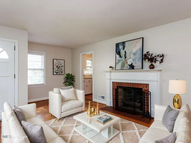 an empty room with wooden floor a fireplace and window