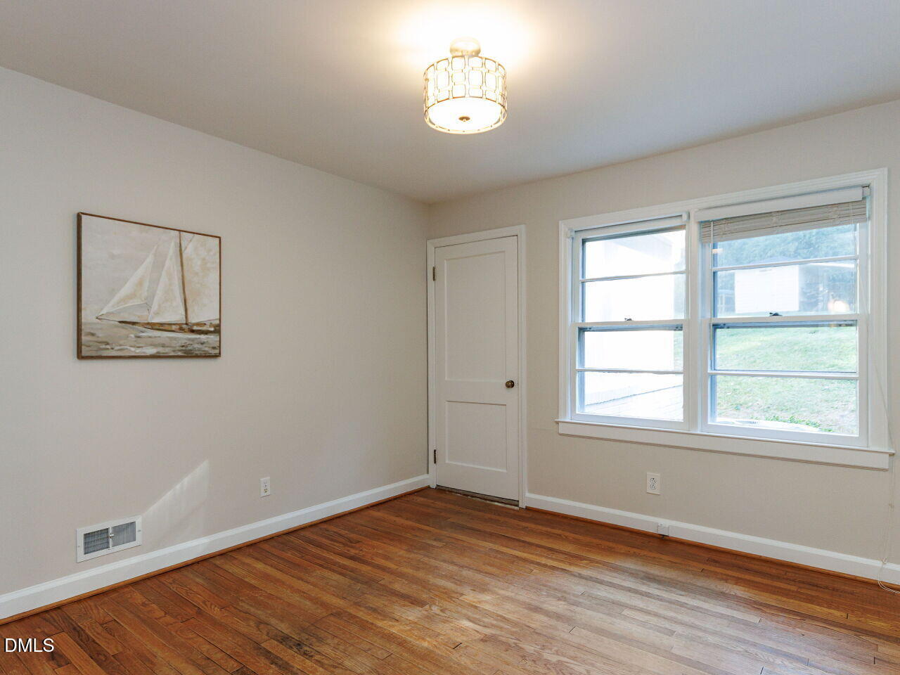 1332 Banbury Road Raleigh, NC 27607 - Photo 20 of 46 a view of an empty room with wooden floor and a window