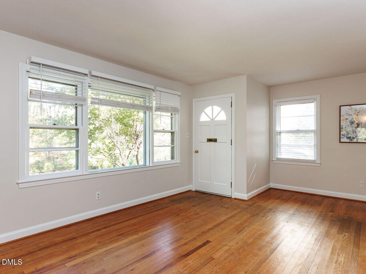 1332 Banbury Road Raleigh, NC 27607 - Photo 6 of 46 a view of an empty room with wooden floor and a window