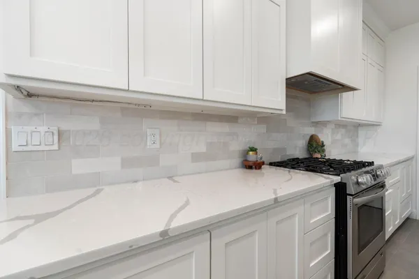 a kitchen with stainless steel appliances granite countertop white cabinets and a stove