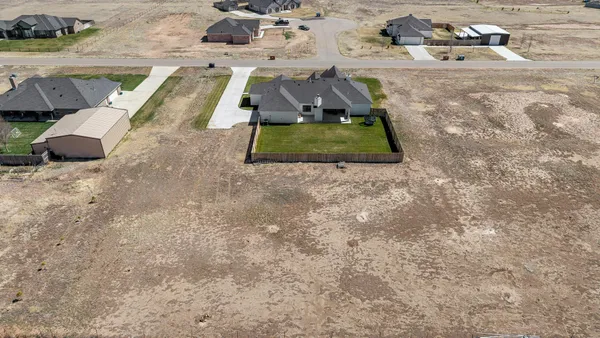 a view of a house with a yard and large tree
