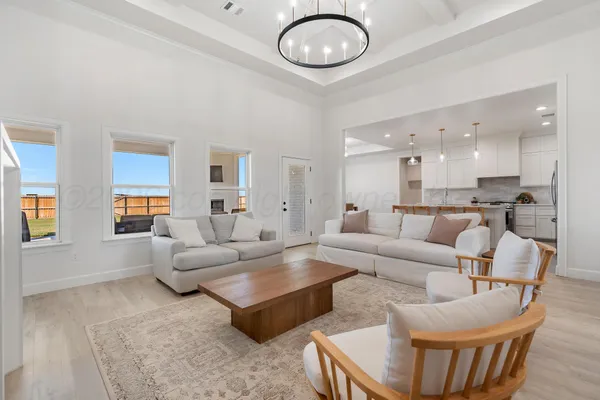 a living room with furniture kitchen view and a large window