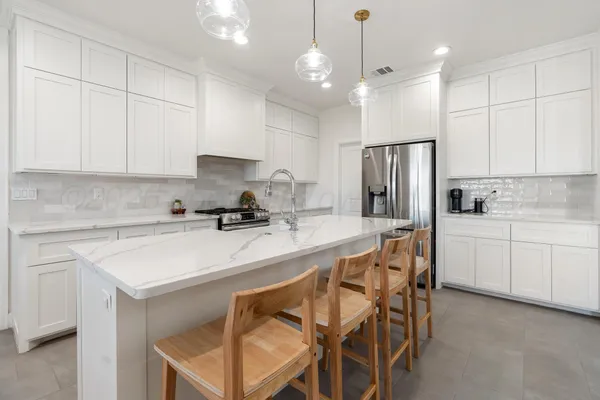 a kitchen with a white center island and cabinets