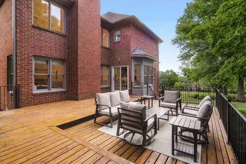 a view of a patio with a dining table and chairs with wooden floor and fence