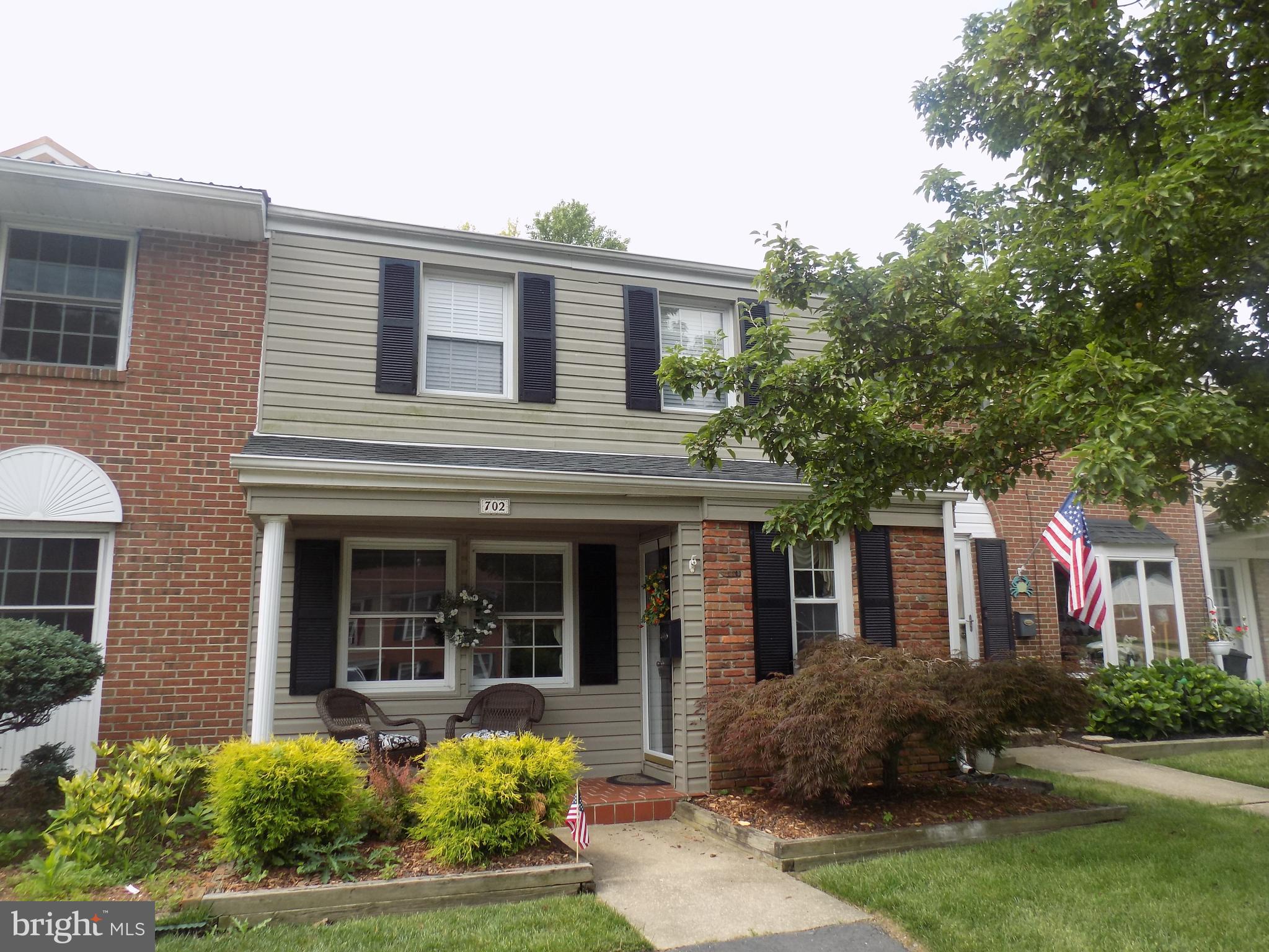 front view of a brick house with a yard