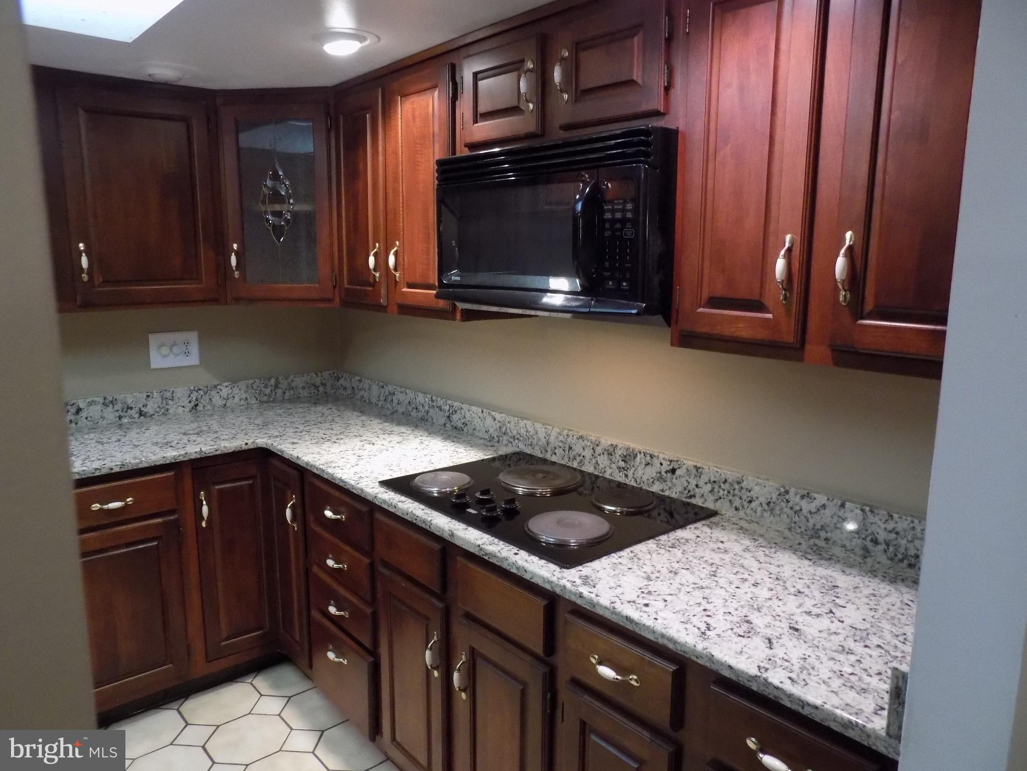 702 Towne Center Drive Joppa, MD 21085 - Photo 12 of 45 a kitchen with granite countertop stove top oven microwave and cabinets