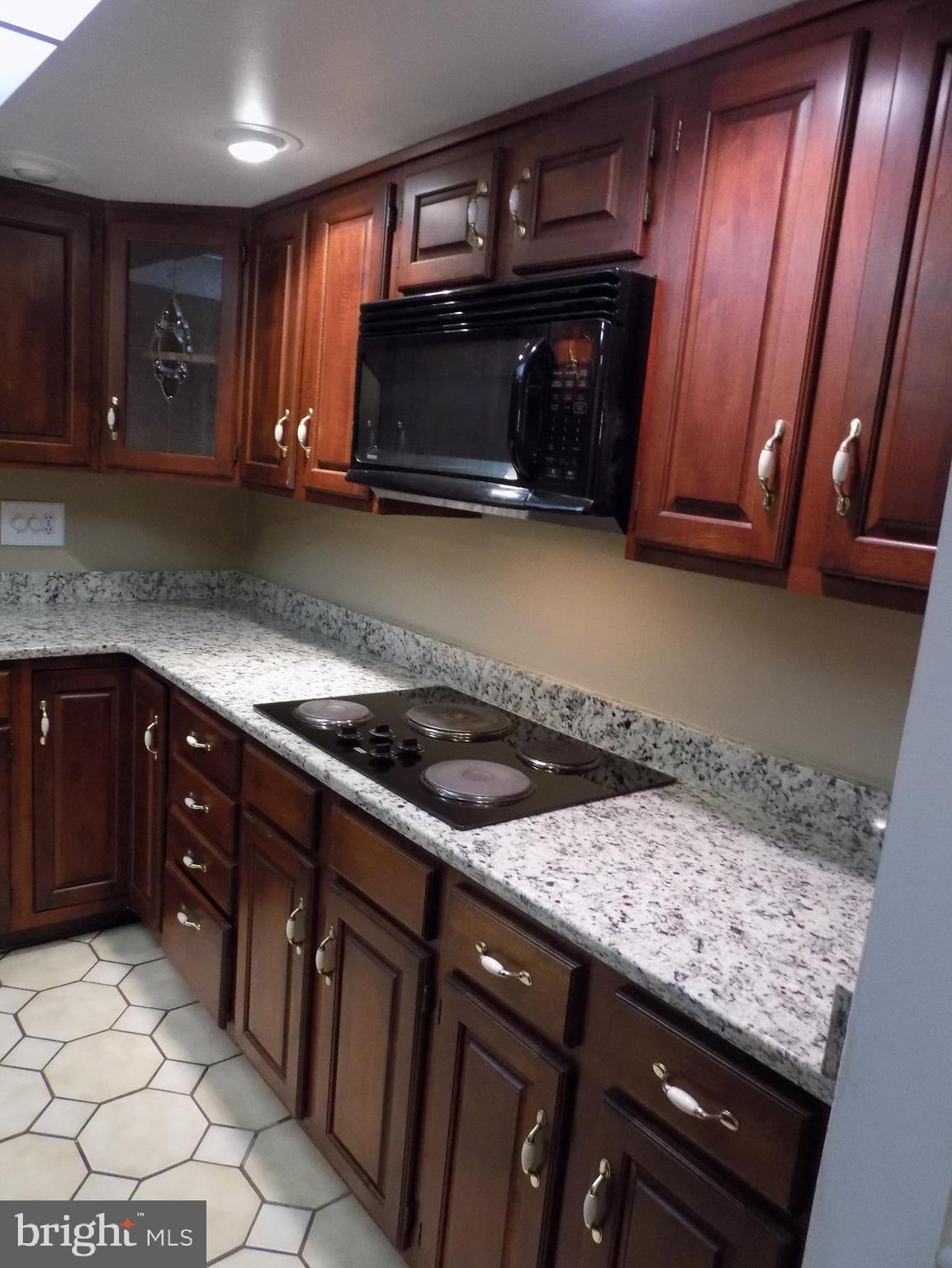 702 Towne Center Drive Joppa, MD 21085 - Photo 13 of 45 a kitchen with granite countertop a sink and a stove