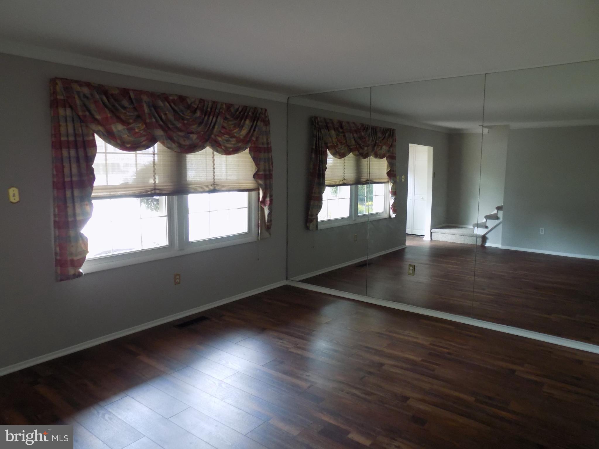 702 Towne Center Drive Joppa, MD 21085 - Photo 3 of 45 a view of an empty room with wooden floor and a window