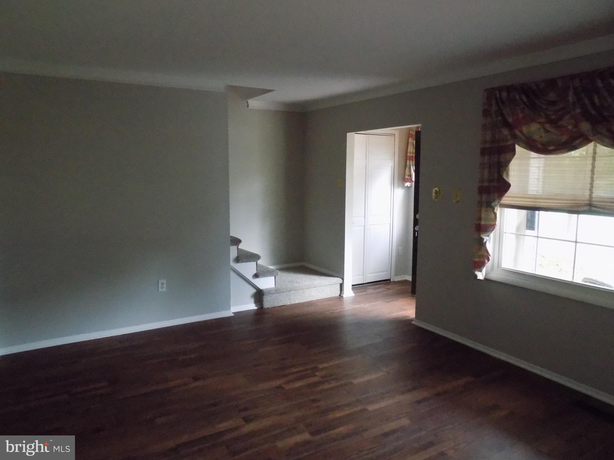 702 Towne Center Drive Joppa, MD 21085 - Photo 4 of 45 a view of an empty room with wooden floor and a window