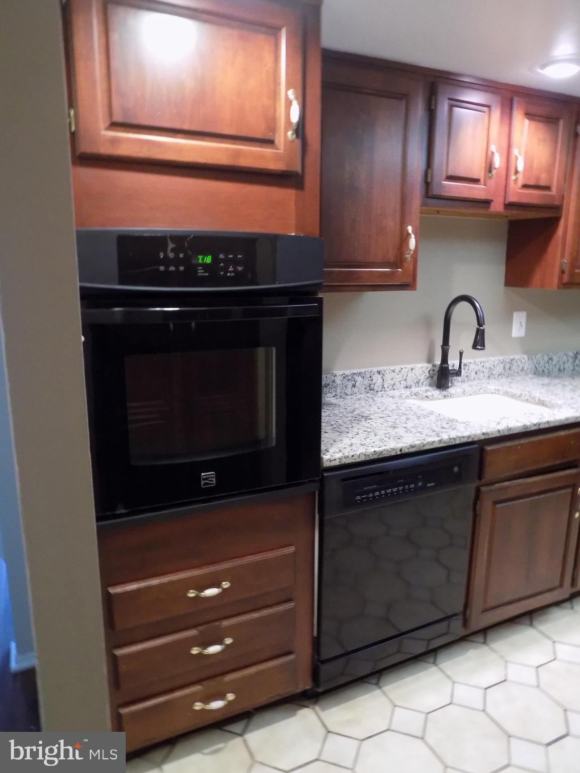 702 Towne Center Drive Joppa, MD 21085 - Photo 9 of 45 a kitchen with granite countertop a stove and a microwave