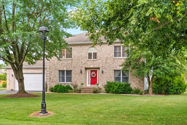 a front view of a house with a yard and trees