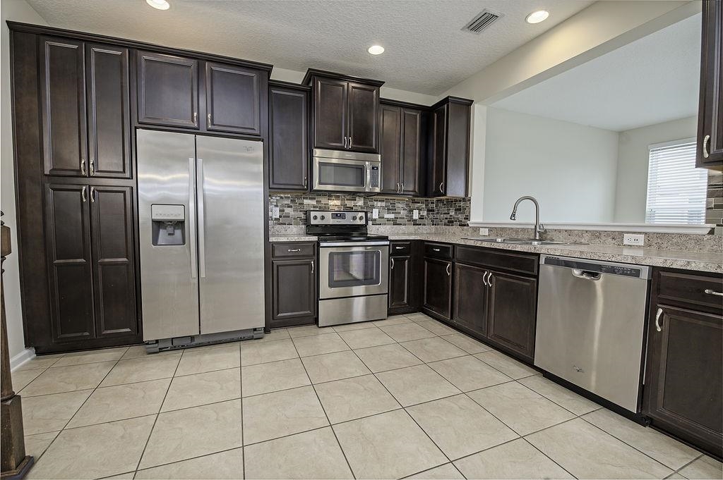 41 Nelson Lane St. Johns, FL 32259 - Photo 11 of 34 a kitchen with stainless steel appliances granite countertop a stove a sink dishwasher a refrigerator and a microwave