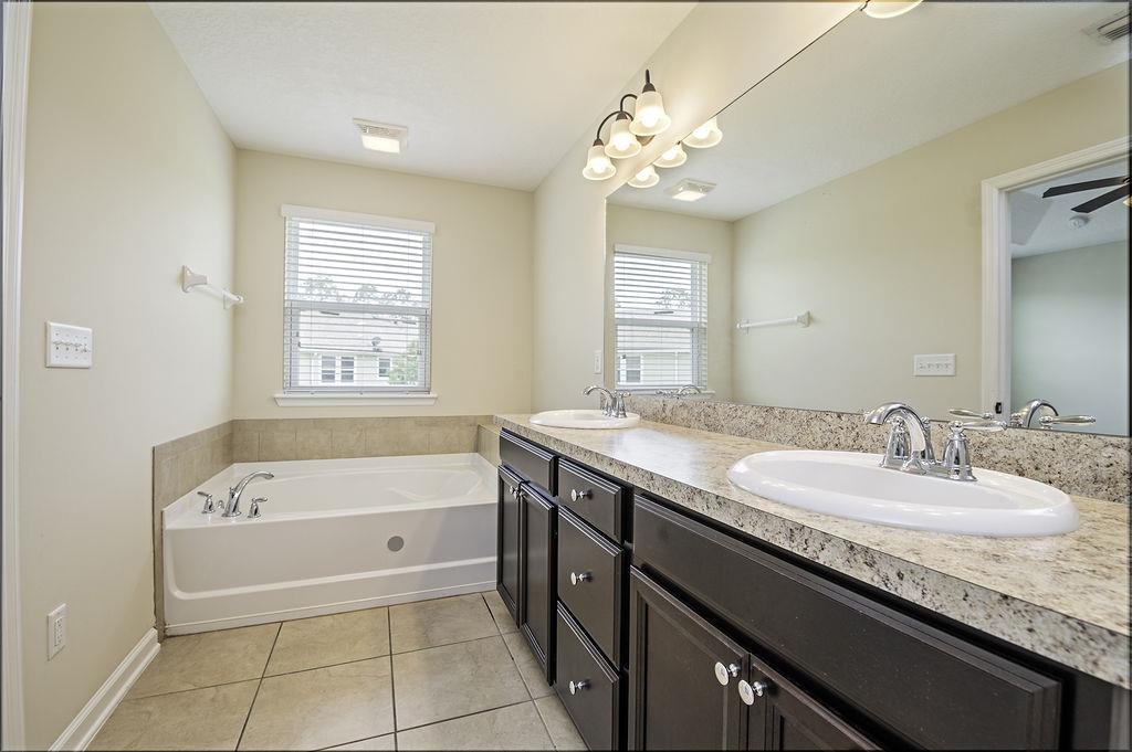 41 Nelson Lane St. Johns, FL 32259 - Photo 26 of 34 a spacious bathroom with a granite countertop bathtub a sink and a mirror