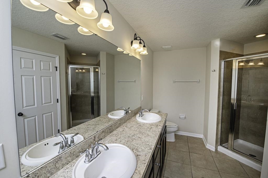 41 Nelson Lane St. Johns, FL 32259 - Photo 27 of 34 a bathroom with a granite countertop sink a mirror and a shower