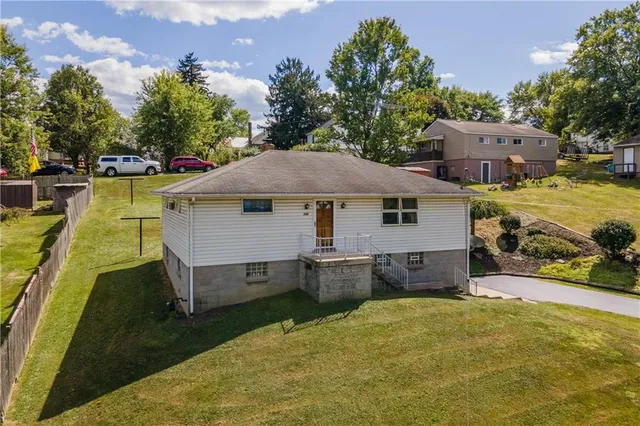 an aerial view of a house with swimming pool and a yard