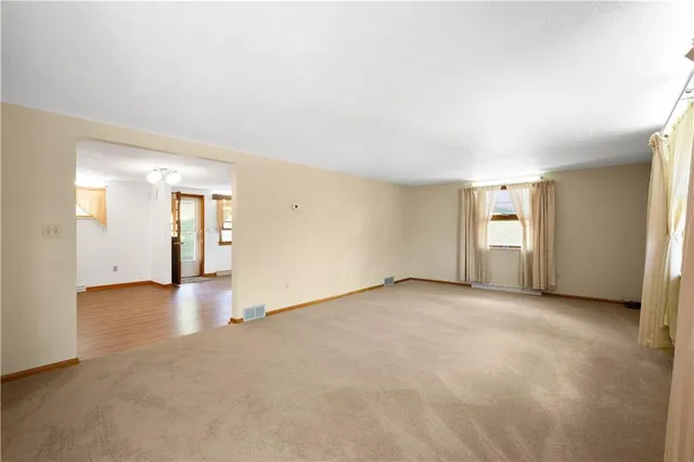 a large kitchen with a center island wooden floor stainless steel appliances and windows