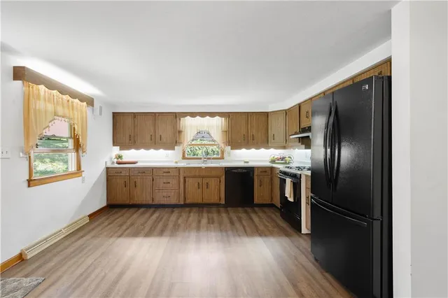 a kitchen with granite countertop stainless steel appliances a refrigerator sink and cabinets