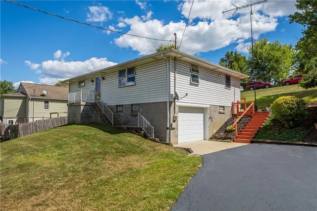 a view of a house with backyard and sitting area