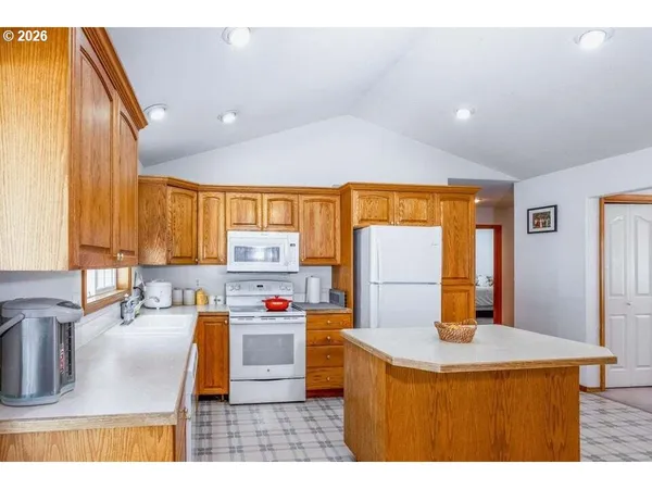 a kitchen with kitchen island a stove a sink a refrigerator and a refrigerator
