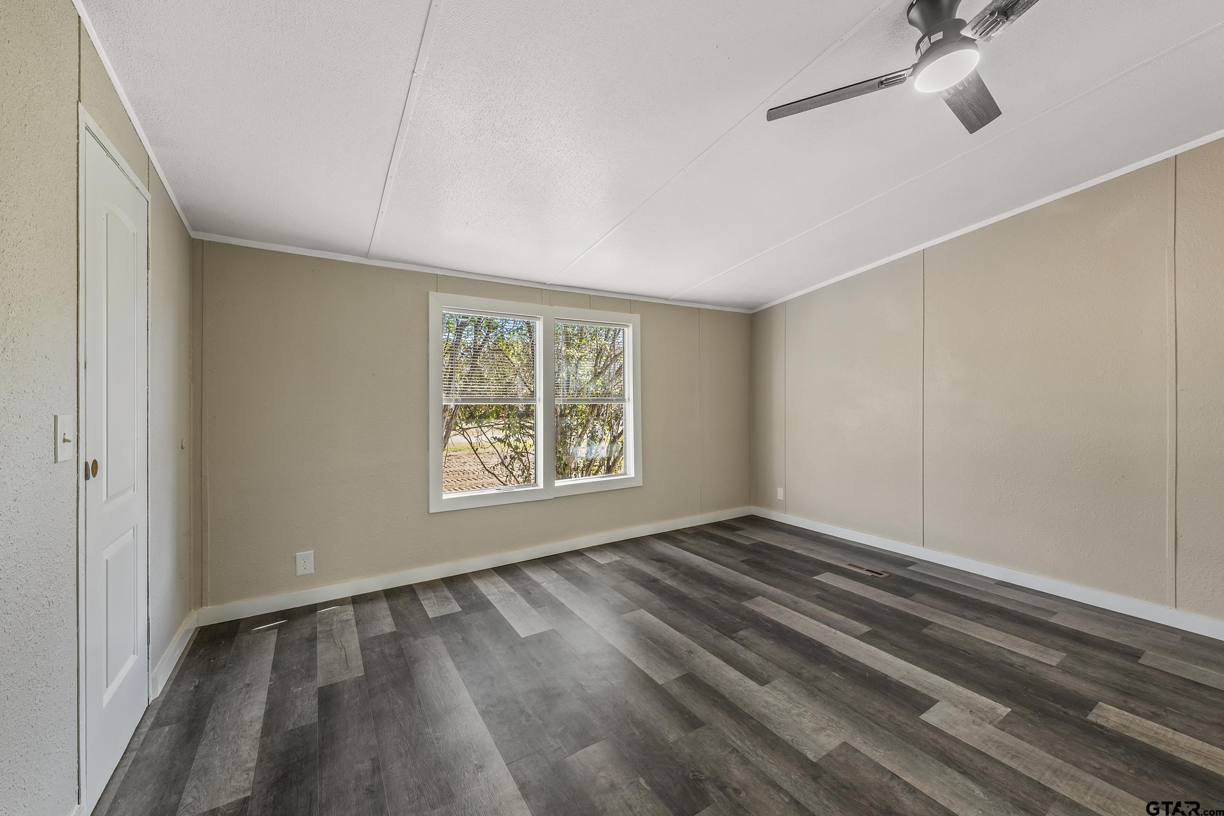 1121 Pecan Ridge Chandler, TX 75758 - Photo 15 of 26 a view of an empty room with wooden floor and a window