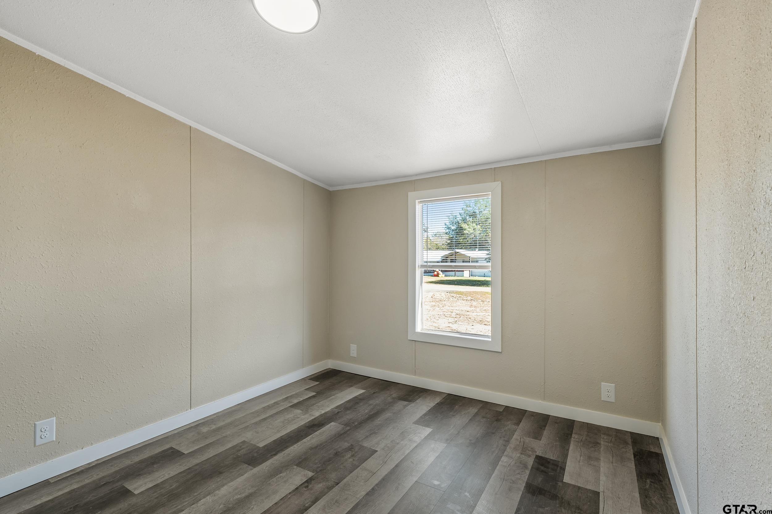 1121 Pecan Ridge Chandler, TX 75758 - Photo 21 of 26 an empty room with wooden floor and windows