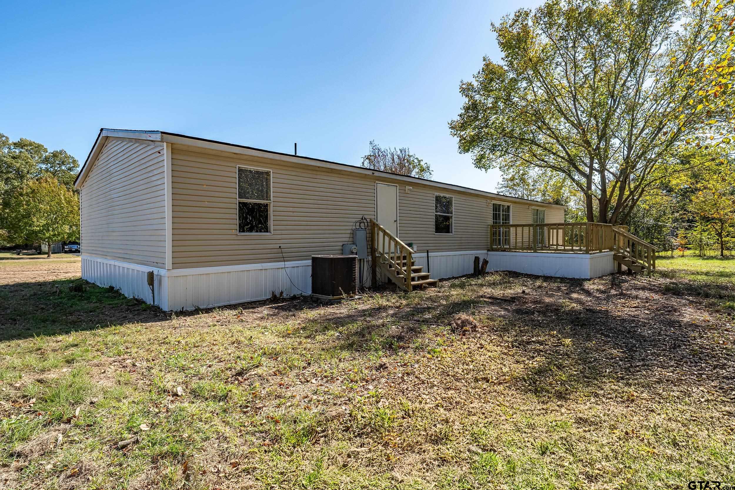 1121 Pecan Ridge Chandler, TX 75758 - Photo 25 of 26 a backyard of a house with barbeque oven and trees