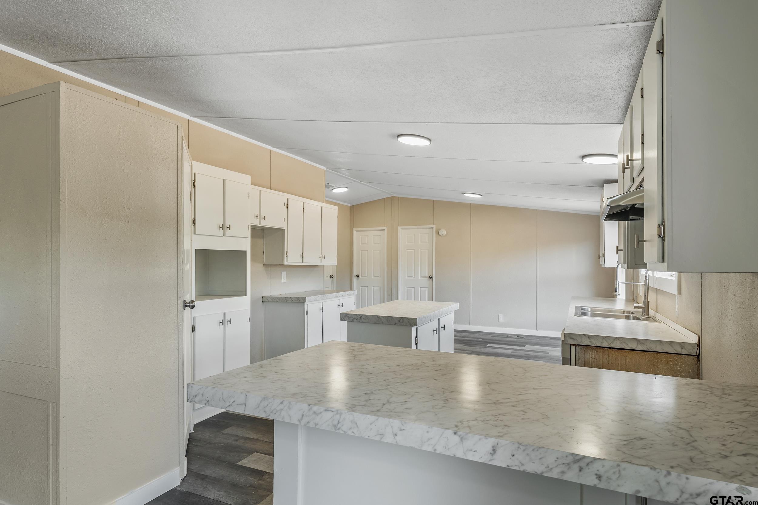 1121 Pecan Ridge Chandler, TX 75758 - Photo 3 of 26 a large kitchen with stainless steel appliances a large counter top and a refrigerator
