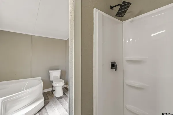 a bathroom with a toilet and a shower