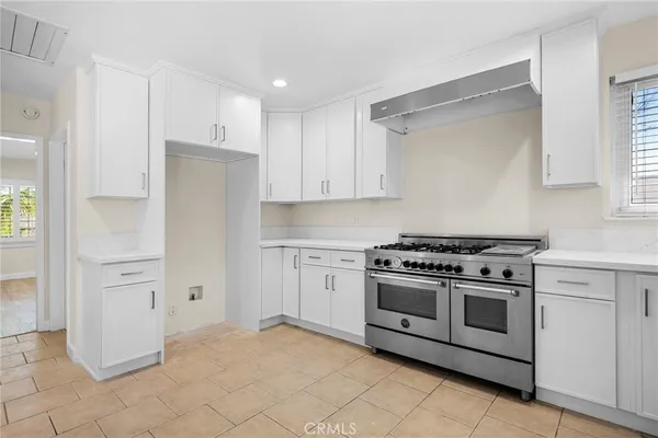 a kitchen with white cabinets and white appliances