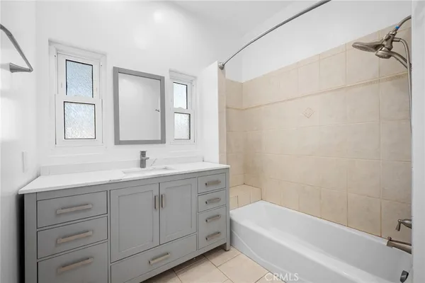 a bathroom with a tub a sink and mirror