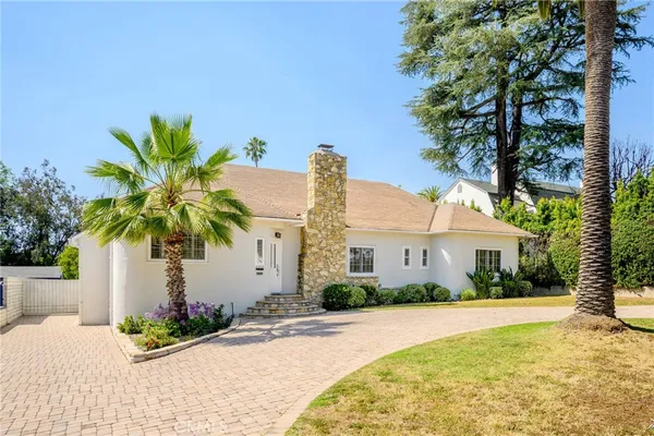 a front view of house with yard and trees around