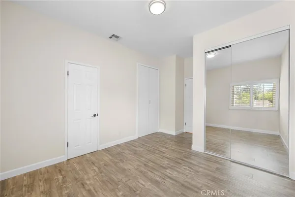 an empty room with closet and windows