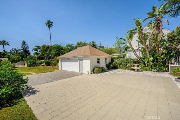 a view of a house with a yard and potted plants