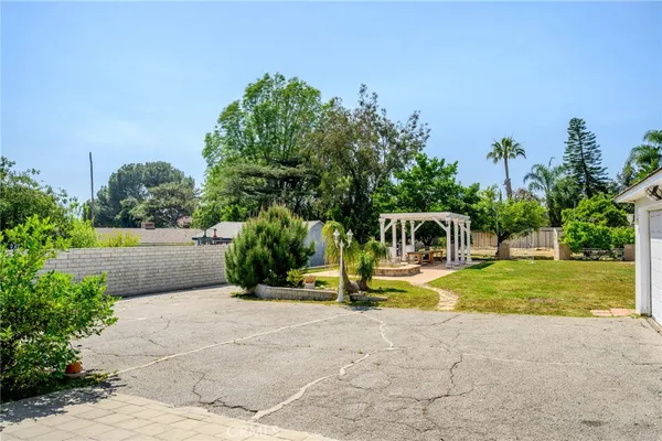 a view of a house with backyard and trees