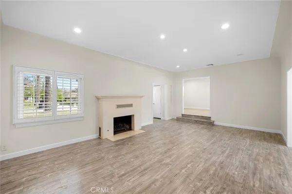 an empty room with windows and fireplace
