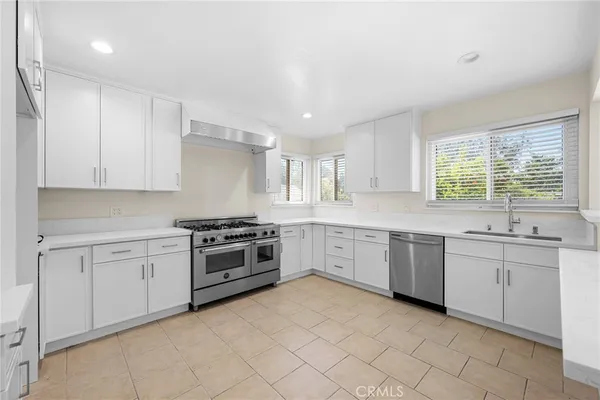 a kitchen with granite countertop a stove top oven sink and cabinets