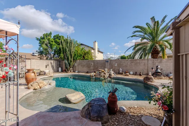 a swimming pool with outdoor seating and plants