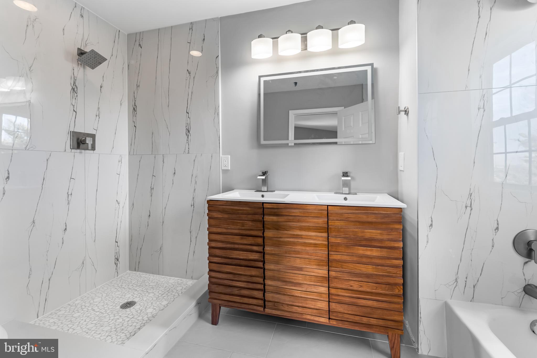 149 58th Street Southeast Washington, DC 20019 - Photo 14 of 32 a bathroom with a sink a mirror and shower