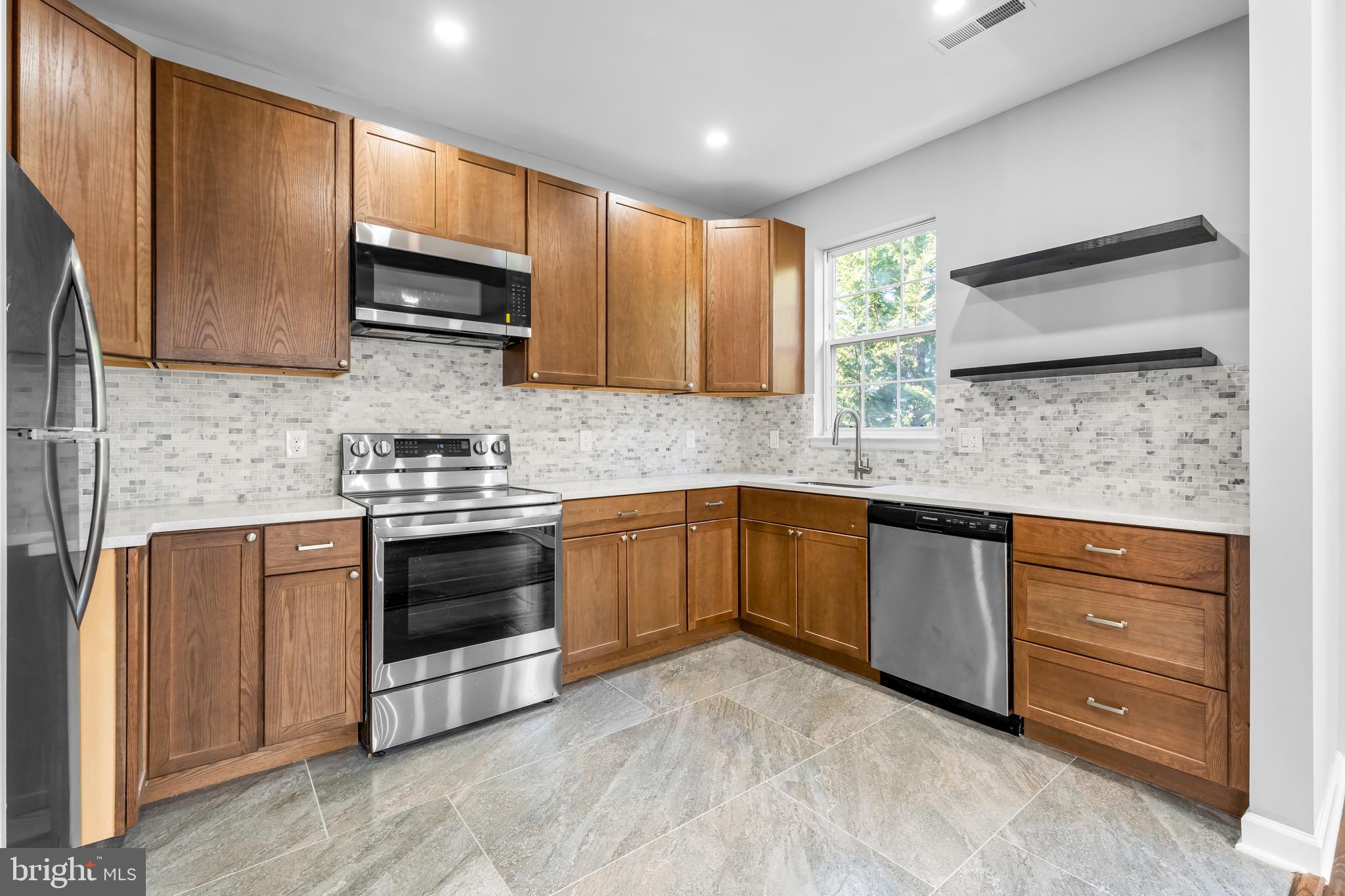 149 58th Street Southeast Washington, DC 20019 - Photo 19 of 32 a kitchen with stainless steel appliances granite countertop wooden cabinets a stove a sink and dishwasher