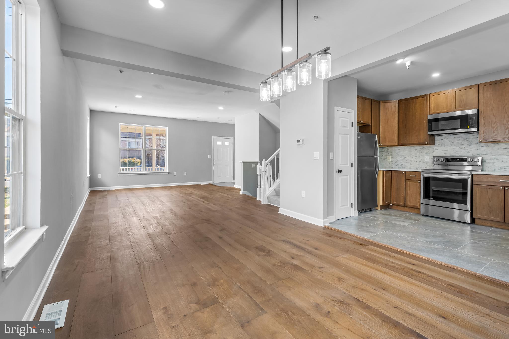 149 58th Street Southeast Washington, DC 20019 - Photo 23 of 32 an empty room with wooden floor kitchen view and a window